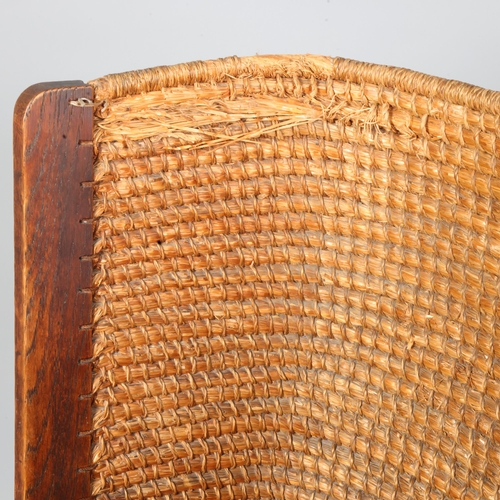 35 - An oak framed Orkney chair, having scrolled arms with wicker back and rush seat, height 99cm, height... 