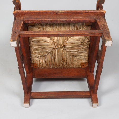 35 - An oak framed Orkney chair, having scrolled arms with wicker back and rush seat, height 99cm, height... 