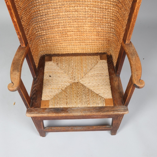 35 - An oak framed Orkney chair, having scrolled arms with wicker back and rush seat, height 99cm, height... 