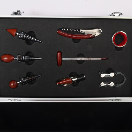 76 - An 8 piece wine accessory set, stainless steel with hardwood handles, in aluminium and faux burr woo... 