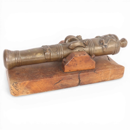 87 - A heavy solid cast-bronze model cannon, on rustic wood stand, barrel length 41cm