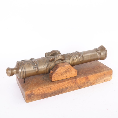 87 - A heavy solid cast-bronze model cannon, on rustic wood stand, barrel length 41cm