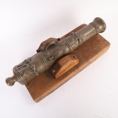 87 - A heavy solid cast-bronze model cannon, on rustic wood stand, barrel length 41cm