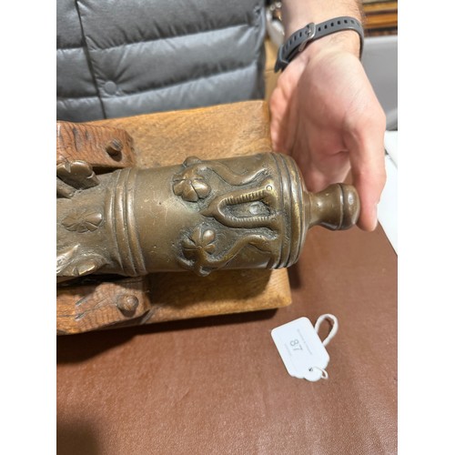 87 - A heavy solid cast-bronze model cannon, on rustic wood stand, barrel length 41cm