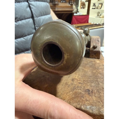 87 - A heavy solid cast-bronze model cannon, on rustic wood stand, barrel length 41cm