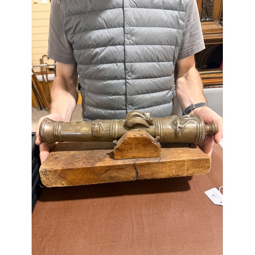 87 - A heavy solid cast-bronze model cannon, on rustic wood stand, barrel length 41cm