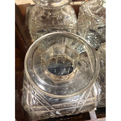 61 - A Victorian oak tantalus with 3 square cut-glass decanters, fold-out lids enclosing 3 liqueur glasse... 