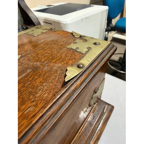 61 - A Victorian oak tantalus with 3 square cut-glass decanters, fold-out lids enclosing 3 liqueur glasse... 