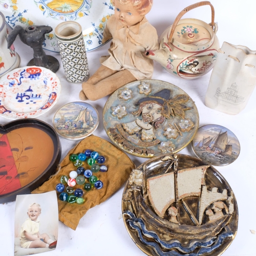 323 - A box of various ceramics, frog surprise mug, Vintage doll, etc.