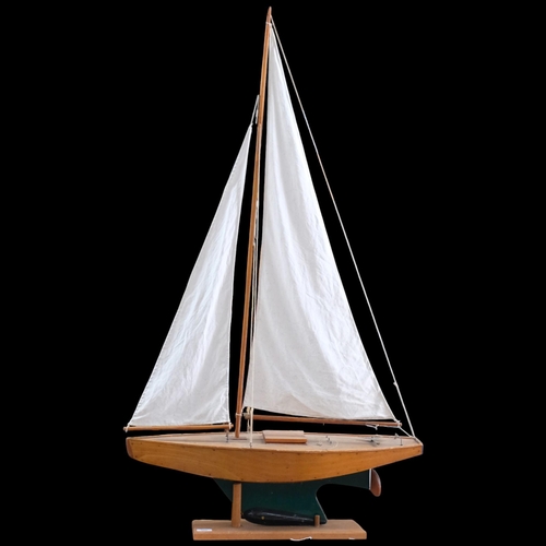 980 - A wood-hulled model pond yacht with sails, on wood stand, overall height 139cm