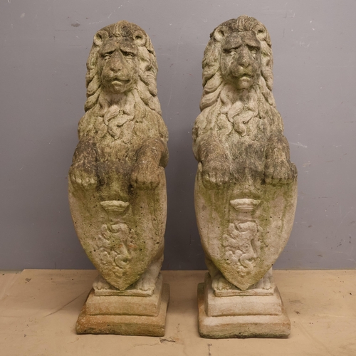 3003 - A pair of weathered concrete statues of armorial lions. Width 24cm, Height 82cm, Depth 32cm.