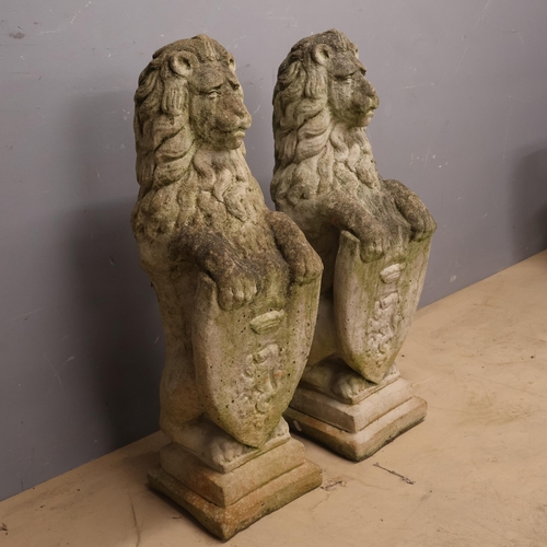 3003 - A pair of weathered concrete statues of armorial lions. Width 24cm, Height 82cm, Depth 32cm.