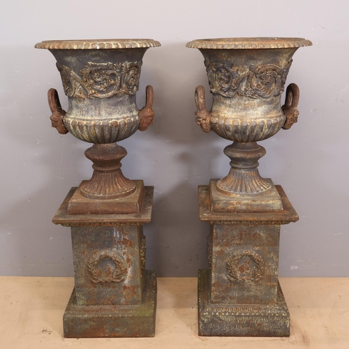 3046 - A pair of large and impressive two section cast iron Medici urns in a neo-classical style with folia... 