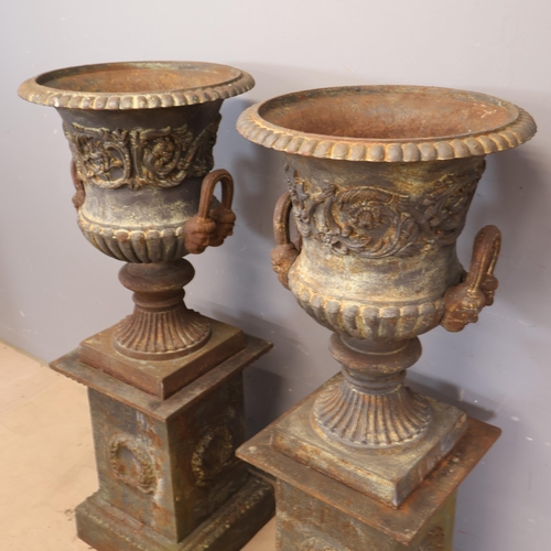 3046 - A pair of large and impressive two section cast iron Medici urns in a neo-classical style with folia... 