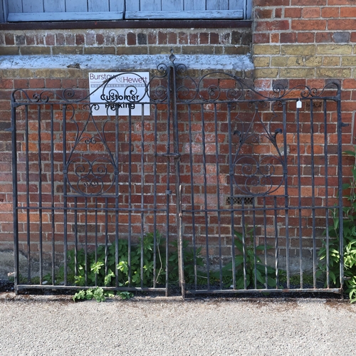 3047 - A pair of painted cast iron gates with hinges and locks. Width (per gate) 114cm, height 173cm.