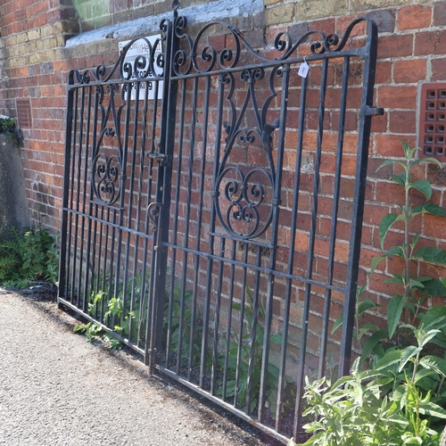3047 - A pair of painted cast iron gates with hinges and locks. Width (per gate) 114cm, height 173cm.