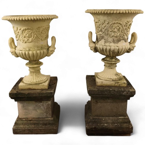 3001 - An pair of antique painted cast iron Medici style garden urns, with two handles and foliate decorati... 