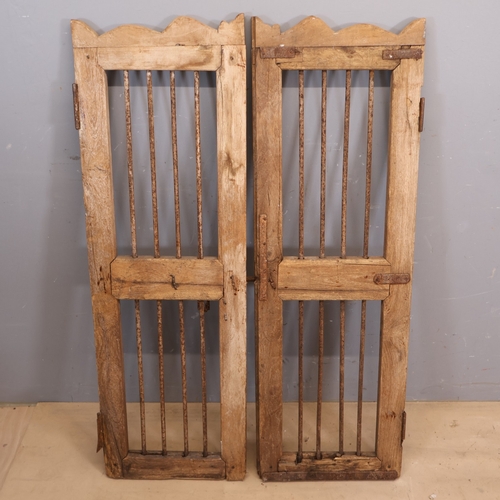 3269 - A pair of oak shutter doors with inset iron bars and bolt lock. Dimensions of each door: Width 40cm,... 