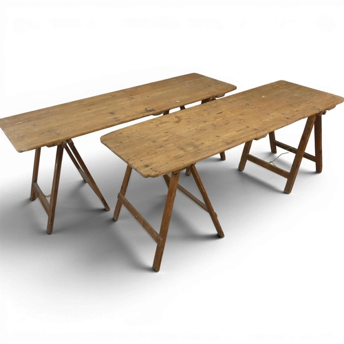 A near pair of vintage pine plank top tables on folding trestle bases ...