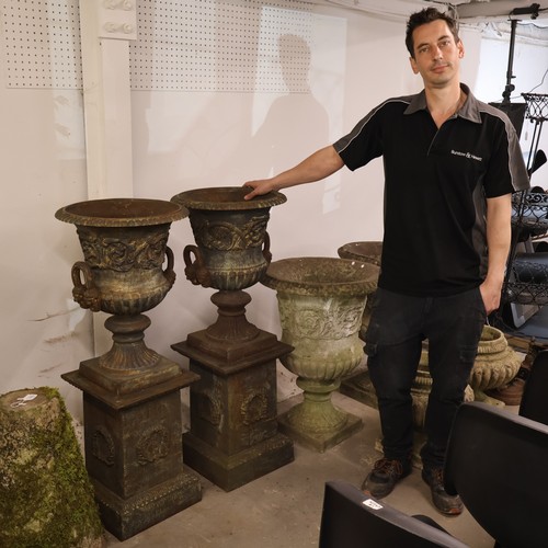 3046 - A pair of large and impressive two section cast iron Medici urns in a neo-classical style with folia... 