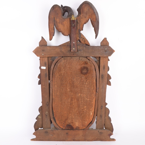 296 - A 19th century Black Forest relief carved and stained wood framed wall mirror, surmounted by a bird,... 
