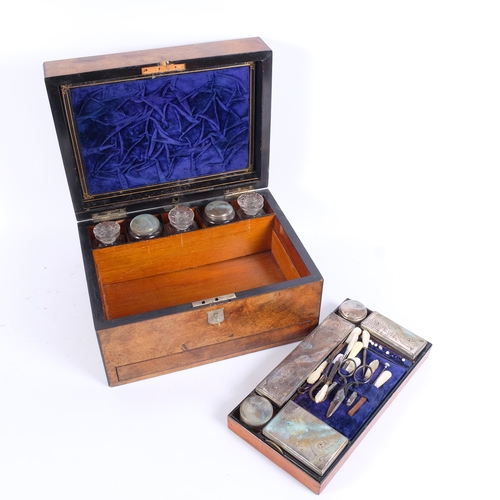 44 - A Victorian walnut travelling toilet case, the interior fitted with original glass jars with plated ... 