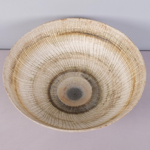 A large stoneware studio pottery bowl, footed with flared rim and ...