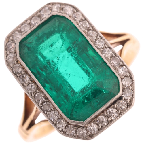 An Art Deco 18ct gold emerald and diamond cluster ring, platinum-topped, rub-over set with 3.80ct octagonal step-cut emerald, surrounded by millegrain set single-cut diamonds, total diamond content approx 0.25ct, emerald weight calculated from measurements: 11.8 x 7.1 x 5.9mm, setting height 16mm, size K, 3.9g