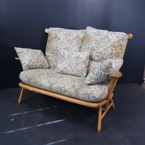 2032 - A contemporary Ercol two seater sofa in solid ash in a light finish with floral upholstered cushions... 