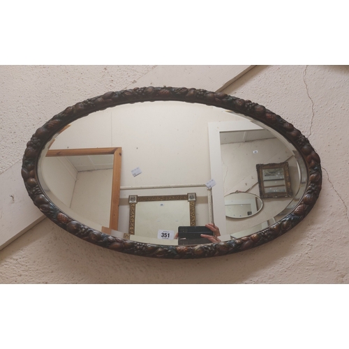 351 - A vintage painted wood framed bevelled oval wall mirror with carved fruit border - sold with a gilt ... 