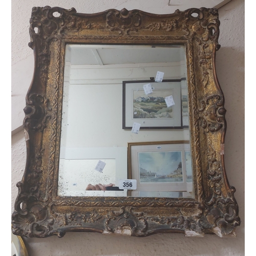 356 - An ornate gilt framed bevelled oblong wall mirror - some loss - sold with a parcel gilt oblong simil... 