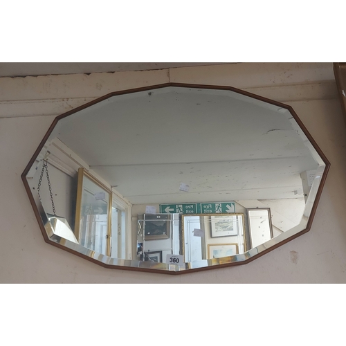360 - A vintage stained wood framed wall mirror with shaped bevelled plate
