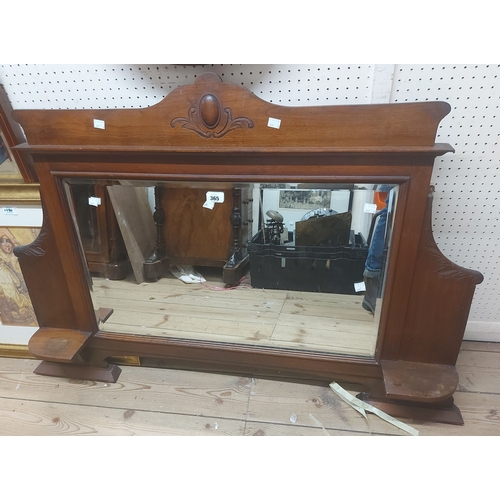 365 - A 1.1m Edwardian stained walnut framed overmantel mirror with bevelled plate and flanking shelves