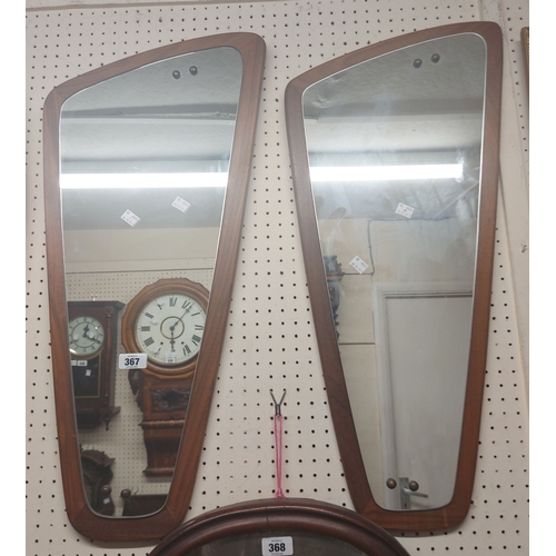 367 - A pair of mid 20th Century teak backed wall mirrors of asymmetrical design