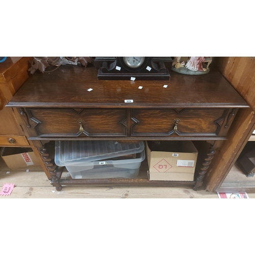 375 - A 1.07m early 20th Century oak side table with raised back and two frieze drawers, set on barley twi... 