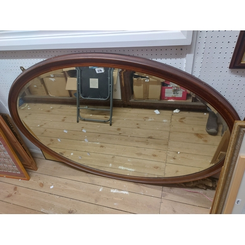 376 - A 1.4m Edwardian mahogany and strung framed bevelled oval wall mirror