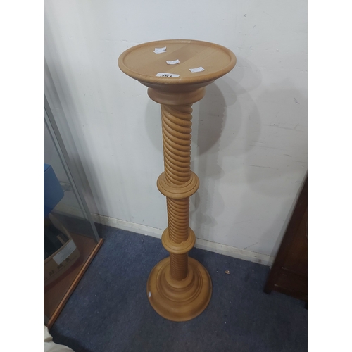 381 - A blonde wood torchère with turned rope twist pillar and circular base