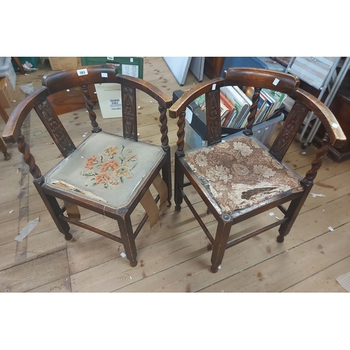 383 - A pair of early 20th Century carved oak framed corner elbow chairs with remains of upholstered seats... 