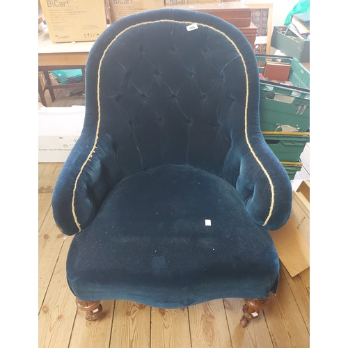 385 - An Edwardian tub chair with button back blue upholstery, set on turned and fluted front legs with br... 