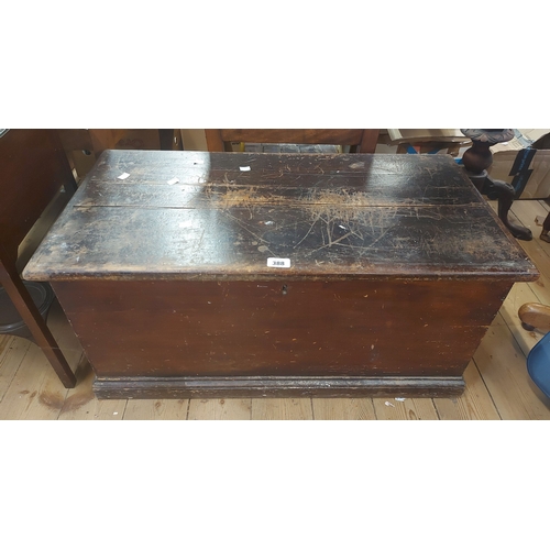 388 - An 85cm antique stained pine lift-top blanket box with internal candle box and flanking iron drop ha... 
