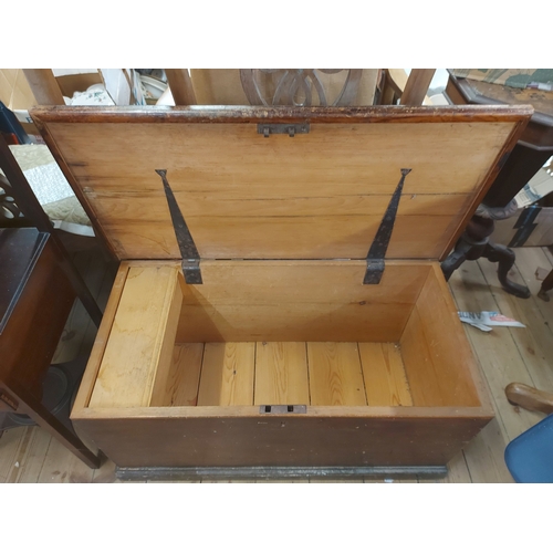 388 - An 85cm antique stained pine lift-top blanket box with internal candle box and flanking iron drop ha... 
