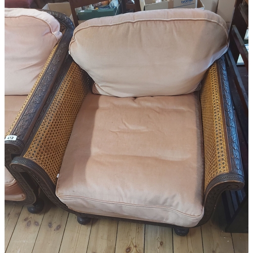 412 - An early 20th Century stained wood framed bergere suite comprising a 1.8m three seater settee and a ... 