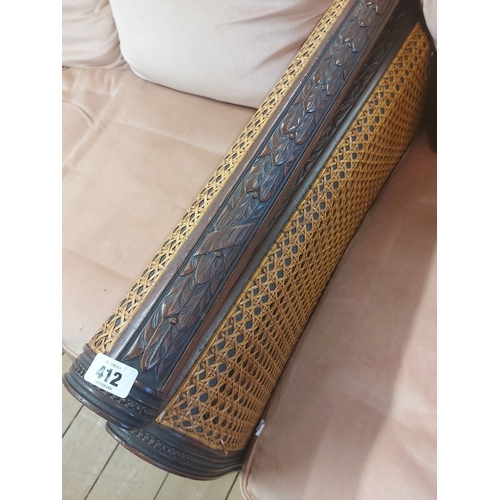 412 - An early 20th Century stained wood framed bergere suite comprising a 1.8m three seater settee and a ... 