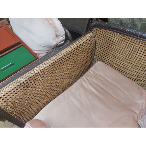 412 - An early 20th Century stained wood framed bergere suite comprising a 1.8m three seater settee and a ... 