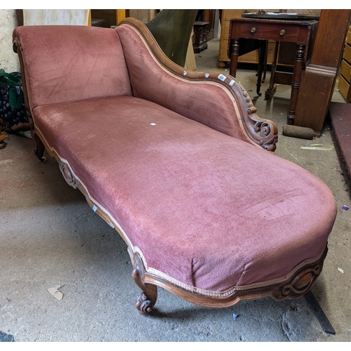 323 - A 1.7m Victorian carved wood part show frame chaise longue with pink velour upholstery, set on carve... 