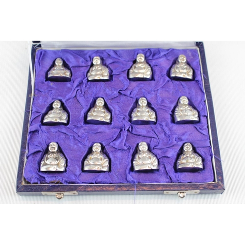 220 - The Princes Trust 'The Noon Foundation' Set of 12 White Metal Menu holders in the form of Buddha