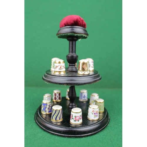 64 - Collection of 15 Royal Crown Derby Thimbles with certificates on a wooden 2 tier stand with surmount... 