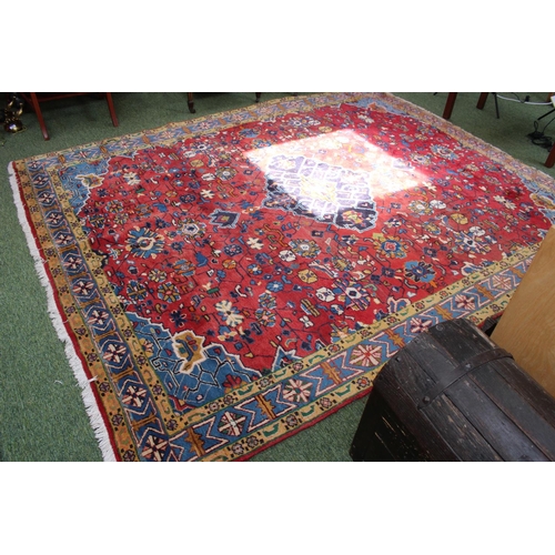 335 - Large Persian Red Ground rug with central medallion and tassel ends 296cm by 240cm