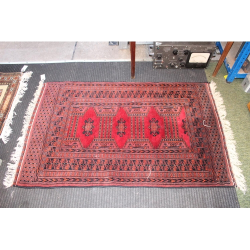 562 - Small Red ground rug with tassel ends 135 x 80cm