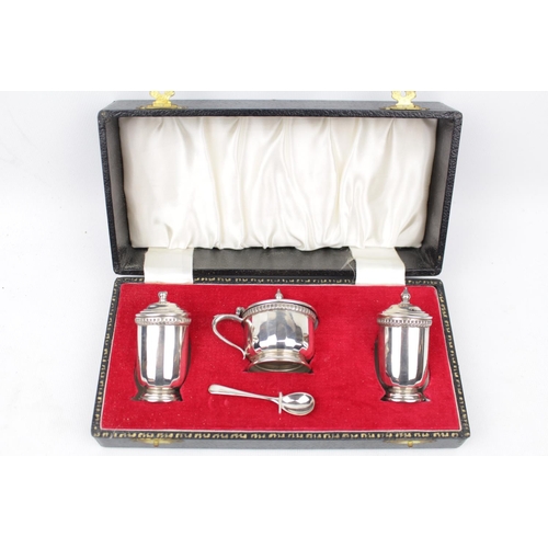 171 - A boxed three-piece cruet set with spoon, Birmingham 1973. 130g total weight excluding blue glass li... 